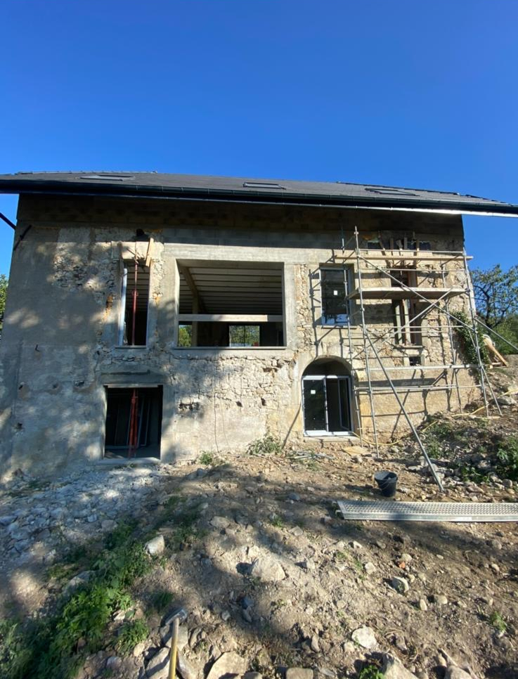 Maison ancienne en pierre avant rénovation : façade brute et ouvertures en cours de création