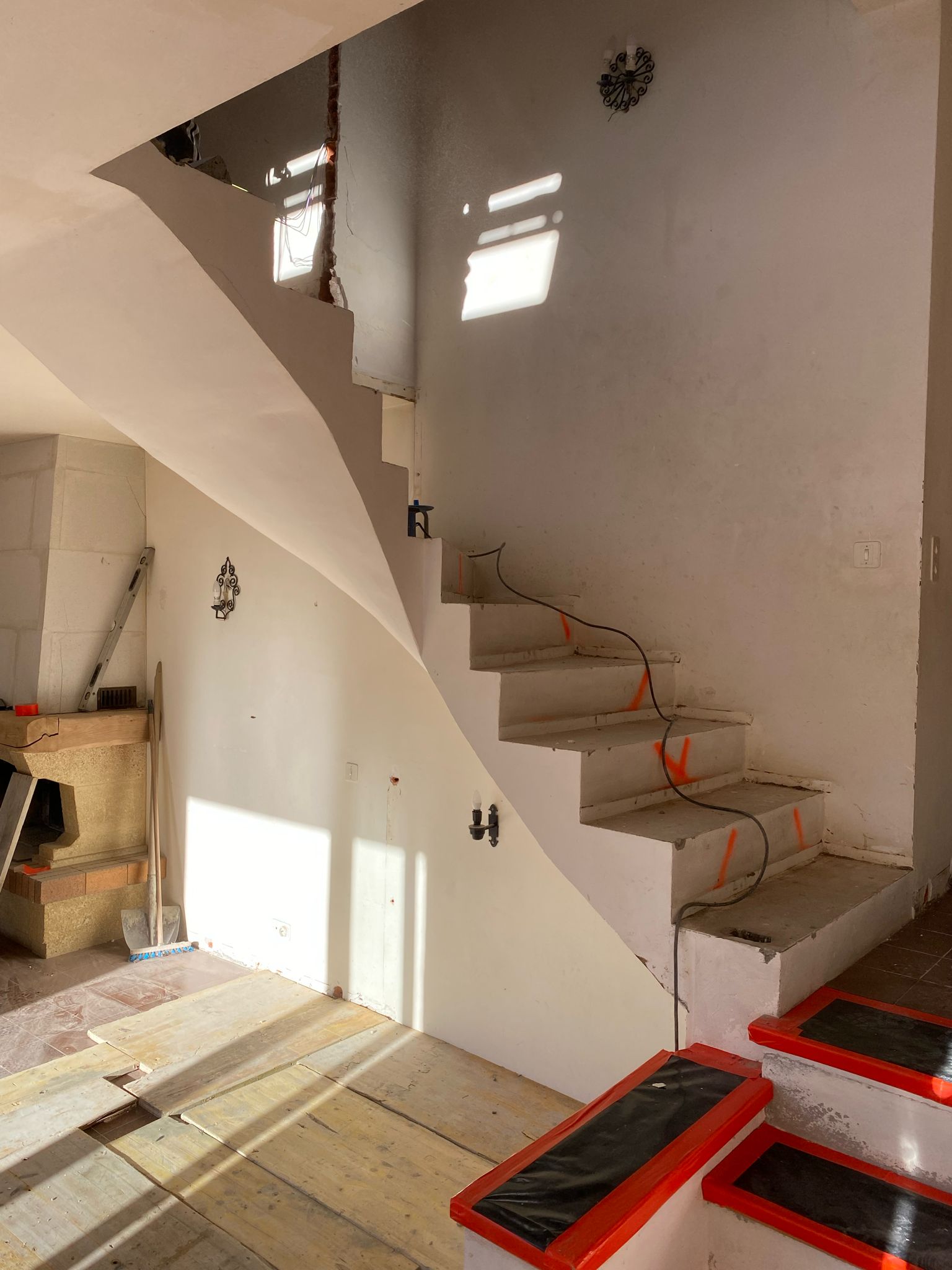 Le même escalier en béton terminé, intégré dans la bâtisse rénovée par AD'M Construction